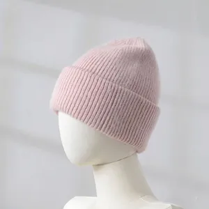 Detailed close-up of a soft pink rabbit hair blend knitted beanie on a white mannequin head