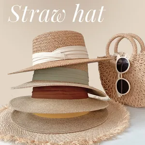 Stack of elegant summer straw hats with colorful ribbon bands for beach sunshade