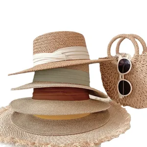 Stack of stylish summer straw hats with colorful ribbons for beach sun protection