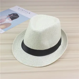 Detail showing the texture of a white woven straw fedora with black ribbon band.
