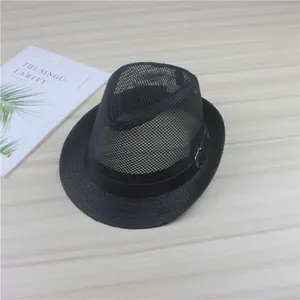 Top view detail of a black mesh fedora hat with straw brim on wooden background.