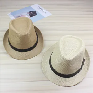 Detailed view of two straw fedora hats in tan and cream colors on a wooden surface