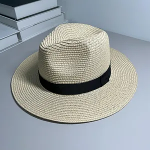 Close-up of a classic Panama straw hat with a stylish black ribbon on gray surface