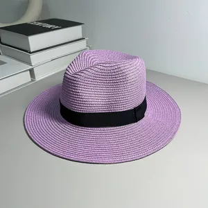 Woven purple Panama straw hat with black ribbon detail on a neutral background