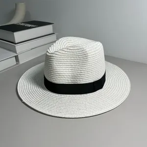 Detail view of white Panama straw hat with black ribbon for sun protection