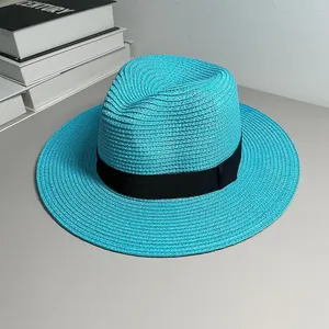 Detailed view of a vibrant turquoise Panama straw hat featuring a classic black ribbon band.