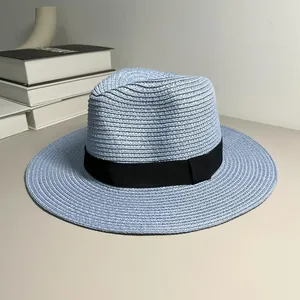 Detail view of a light blue straw Panama hat with a stylish black band for summer.