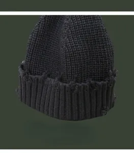 Detailansicht der destroyed Optik und des Rippstrickmusters dieser dunklen Wollmütze