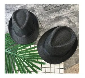 Detailed view of two stylish black straw fedora hats with ribbons for parent and child