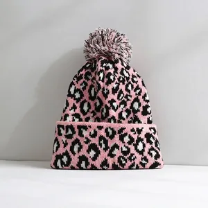 Pink and black leopard print knitted beanie with a soft decorative pom-pom top