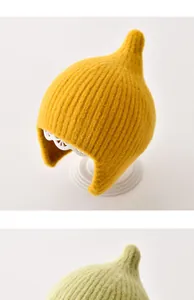 Schattige gebreide babymuts met oorbescherming in een heldere mosterdgele kleur.