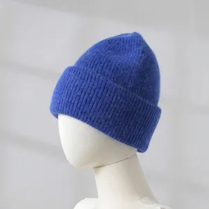 Macro view of soft blue knit beanie texture with thick folded brim on white mannequin