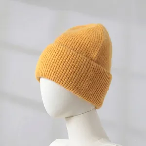 Detailed view of the soft rabbit hair knitted texture on a yellow winter beanie hat.