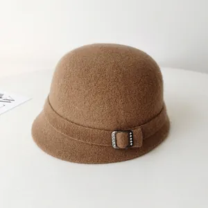 Close-up of elegant brown wool felt cloche hat with a chic rhinestone buckle detail