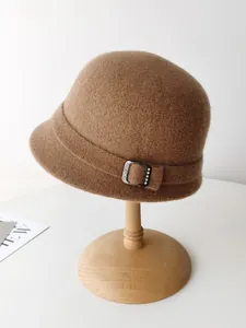 Detailed view of elegant brown wool felt cloche hat featuring a sparkling buckle detail