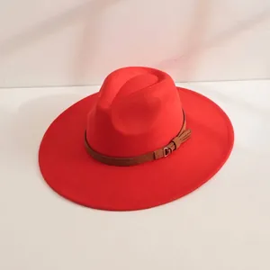 Détail d'un chapeau fedora en laine rouge à large bord avec bande en cuir marron.