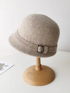 Close-up detail of a vintage oatmeal wool felt cloche hat with rhinestone buckle accent