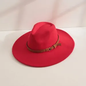 Gros plan d'un chapeau fedora en feutre rouge à larges bords avec ceinture marron