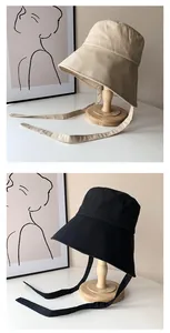 Detailansicht von beige und schwarzen Fischerhüten im koreanischen Stil mit Kinnriemen