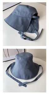 Detailansicht eines blauen Sonnenhuts mit verstellbarem Kinnriemen und breiter Krempe.