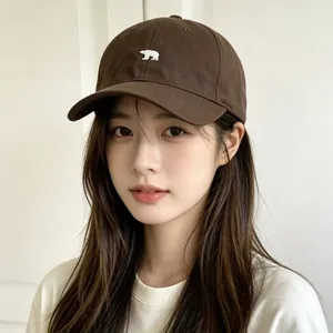 Casquette de baseball marron avec broderie d'ours polaire blanc sur un mannequin