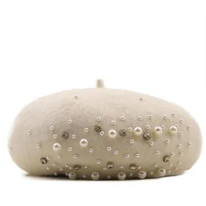 Detail view of elegant pearl and rhinestone embellishments on cream wool beret hat.