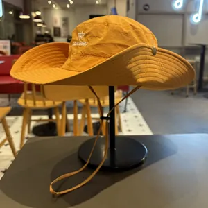 Detailed view of an orange outdoor sun hat with embroidered logo on a display stand