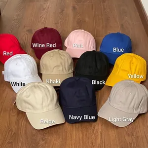 Washed cotton baseball caps in multiple colors displayed on a wooden floor background