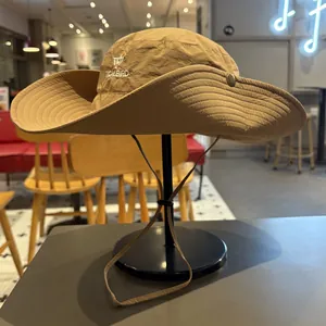 Detailed view of khaki hiking sun hat with TICALBIRD embroidery on black stand