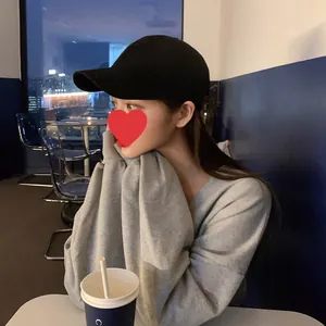 Classic washed cotton solid black baseball cap worn by model in a cafe setting