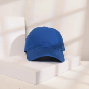 Detail einer königsblauen Baumwoll-Basecap auf einem minimalistischen weißen Podest.