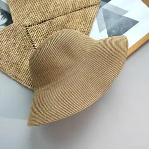 Detailed close-up view of a minimalist woven straw sun hat for women on a neutral mat