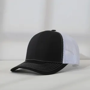 Detail of a black and white mesh trucker hat showing the contrast stitching on the brim