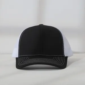 Front view detail of a black and white mesh trucker hat with white contrast stitching