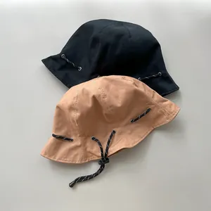 Detailansicht der doppelseitigen Fischerhüte in Schwarz und Khaki mit Kordelzug