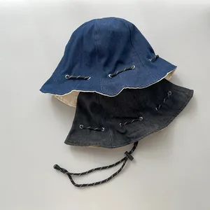 Detailaufnahme von blauen und schwarzen Denim-Fischerhüten mit verstellbaren Kordeln