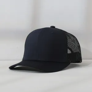 Side profile detail of a classic black mesh trucker hat featuring a breathable net back.