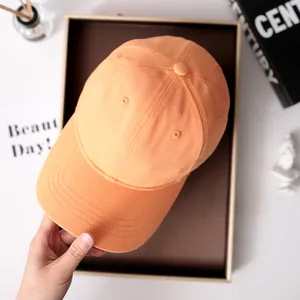 Detaillierte Draufsicht auf eine orangefarbene Baseballkappe aus Baumwolle in Geschenkbox