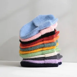 Stack of colorful knitted winter beanie hats for women in various vibrant color options