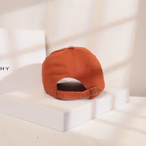 Rückseite einer orangefarbenen Baumwoll-Basecap mit verstellbarer Metallschnalle.