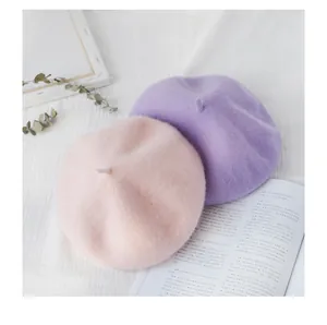 Roze en paarse wollen baretten op een witte esthetische achtergrond met magazine