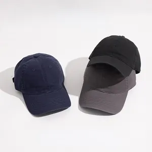 Gros plan sur des casquettes de baseball minimalistes en bleu marine, noir et gris.