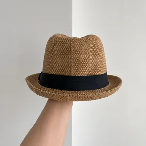 Dettaglio del cappello di paglia fatto a mano con fascia nera e trama intrecciata