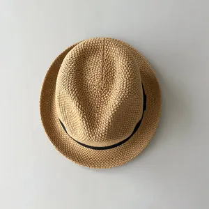 Vista dall'alto di un cappello jazz in paglia lavorato a mano all'uncinetto con nastro nero