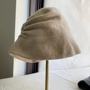 Detailed side view of elegant beige wool bucket hat featuring stylish pleated design texture