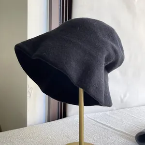 Side view of a black pure wool slouchy bucket hat on a display stand
