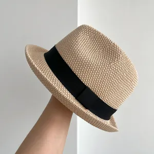Dettaglio di un elegante cappello jazz in paglia fatto a mano con nastro nero classico.
