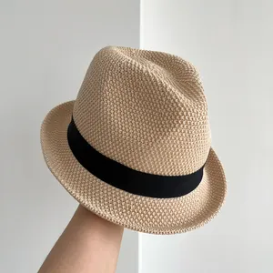 Vista dettagliata di un cappello da sole fedora beige lavorato a mano con nastro nero.