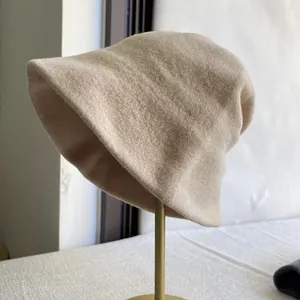 Elegant beige Australian wool bucket hat for women displayed on a gold stand for winter