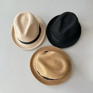 Tre cappelli fedora all'uncinetto in beige, nero e marrone su sfondo grigio